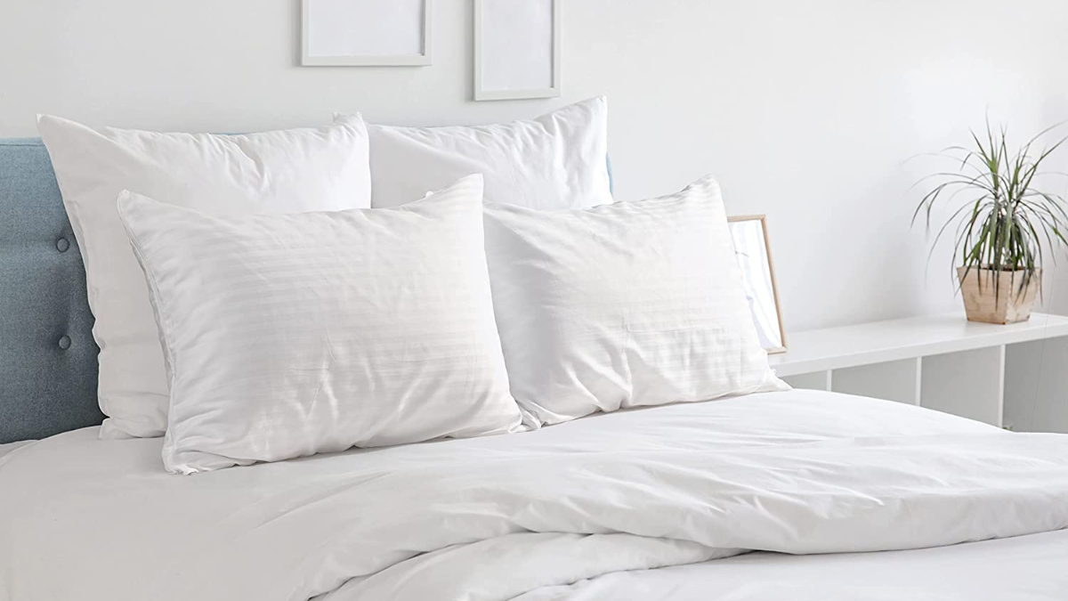 A neatly arranged bed with crisp, white pillows and bedding, creating a clean and serene bedroom atmosphere. Minimal decor complements the fresh and inviting setup.