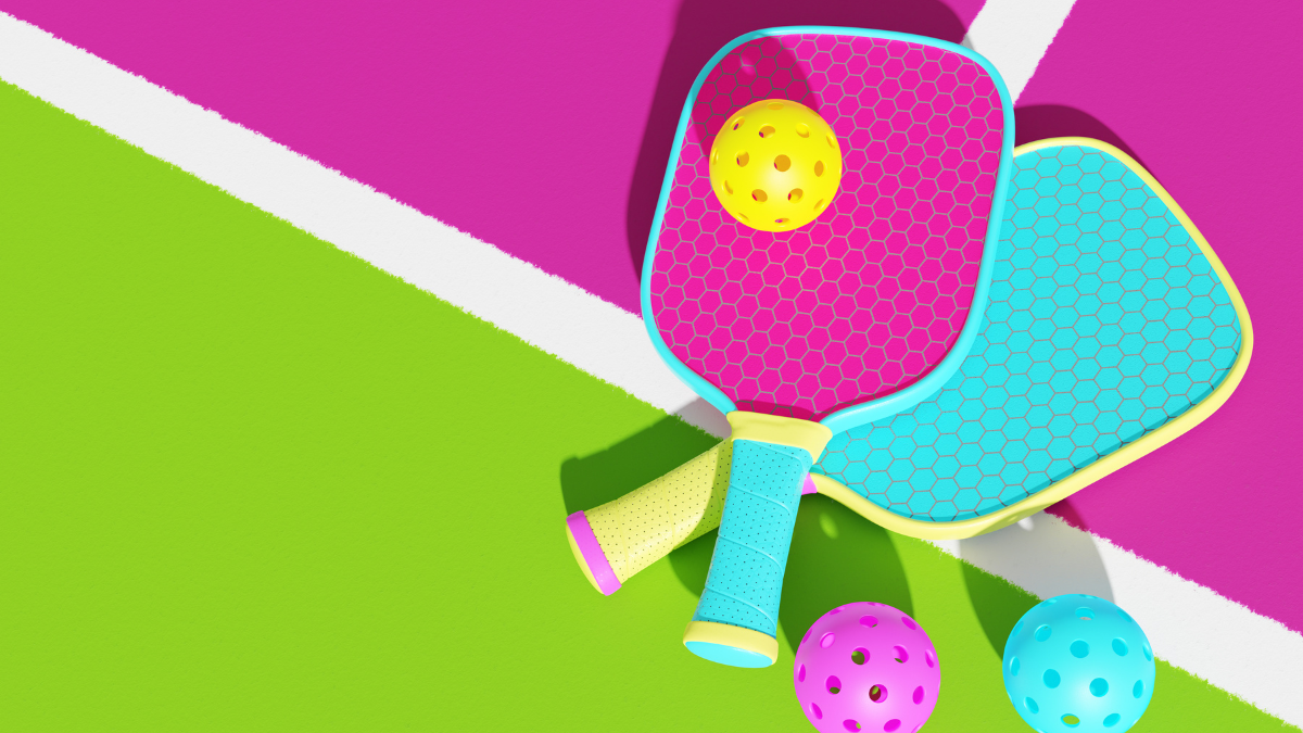 This vibrant image features colorful pickleball paddles and balls set on a bright, eye-catching court with pink and green sections, emphasizing the sport's playful and energetic vibe.