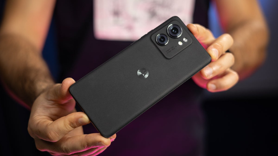 A person holding a sleek black smartphone featuring a dual-camera setup on the back.