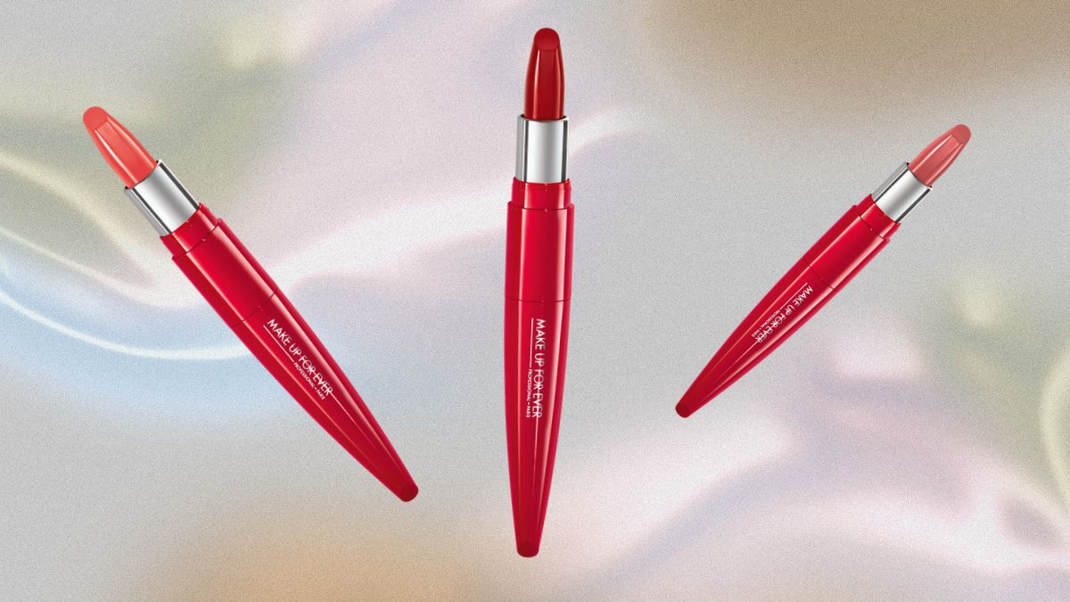 A trio of Make Up For Ever Rouge Artist Shine On Lipsticks in sleek red packaging, displayed against a soft, iridescent background.