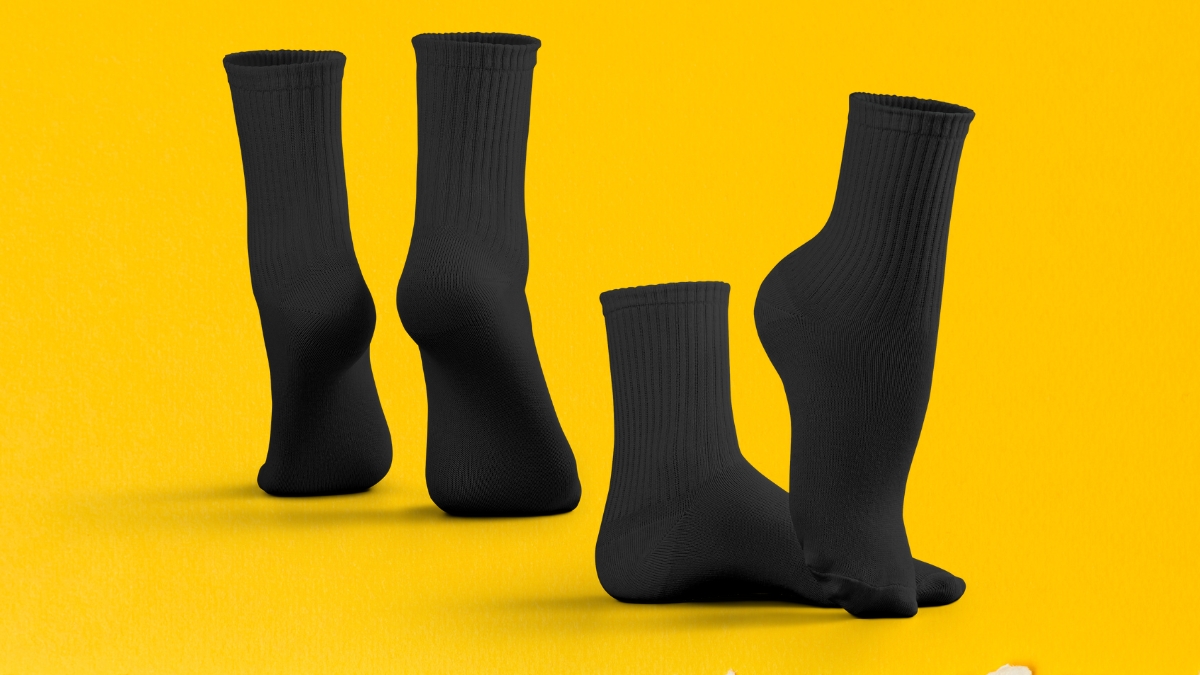 Pairs of black sport socks displayed against a bright yellow background.