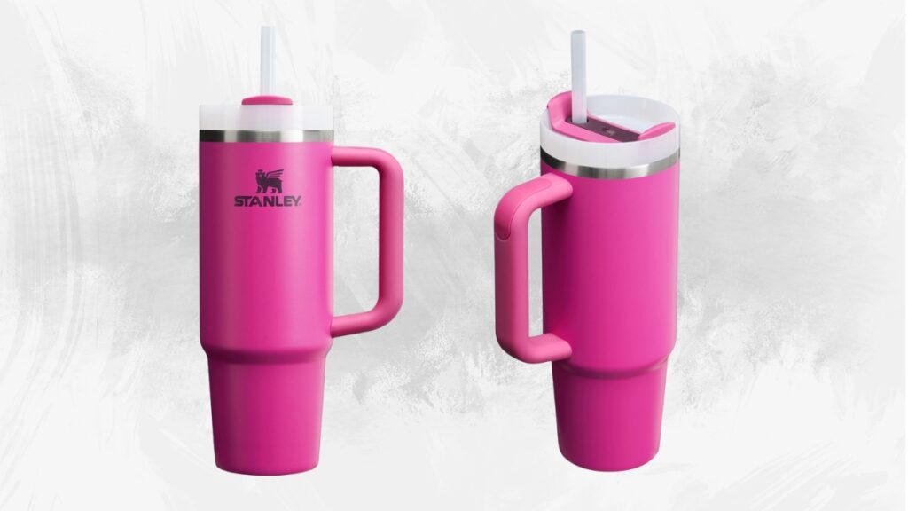 A bright pink Stanley tumbler with a handle and straw is shown from two angles against a textured white background.