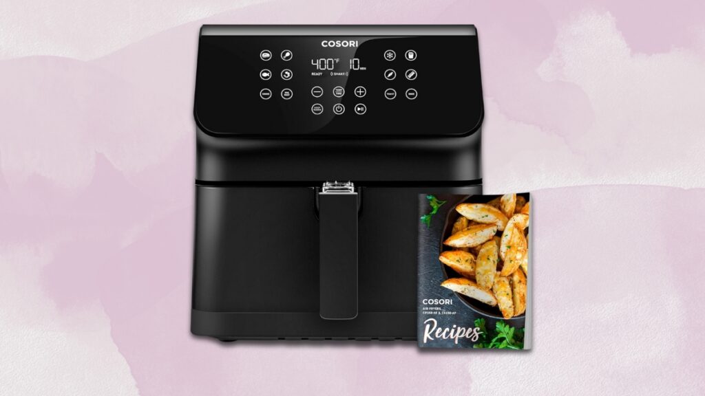 A black Cosori air fryer with a digital display is shown alongside a recipe book featuring crispy potato wedges.