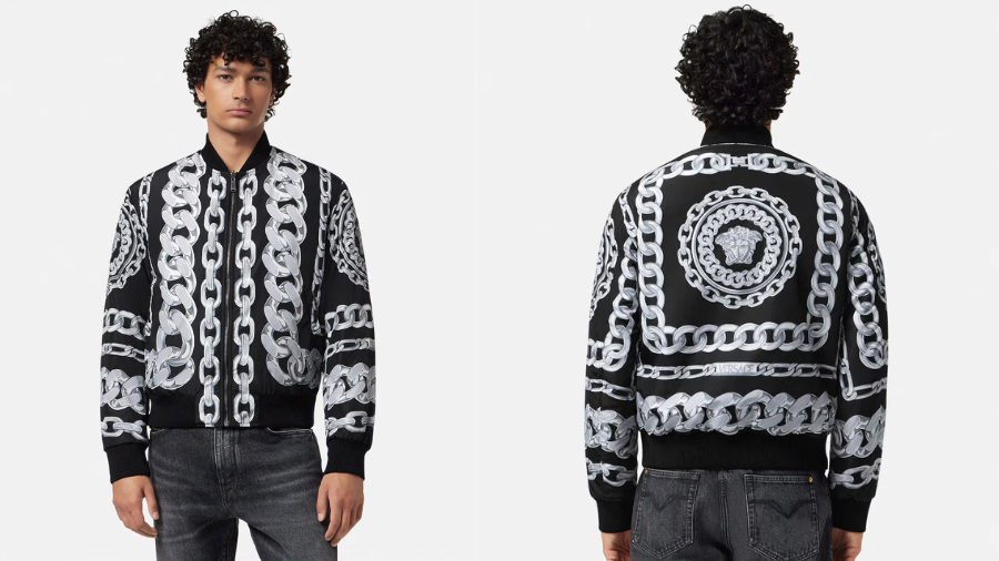 A black bomber jacket with bold silver chain prints is showcased. On the left, a male model wears it with jeans, highlighting its fitted silhouette.