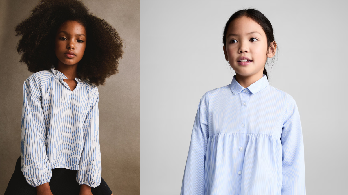 Two young girls wear stylish striped button-up shirts. The girl on the left wears a relaxed-fit white and blue striped blouse with voluminous sleeves, paired with black pants.