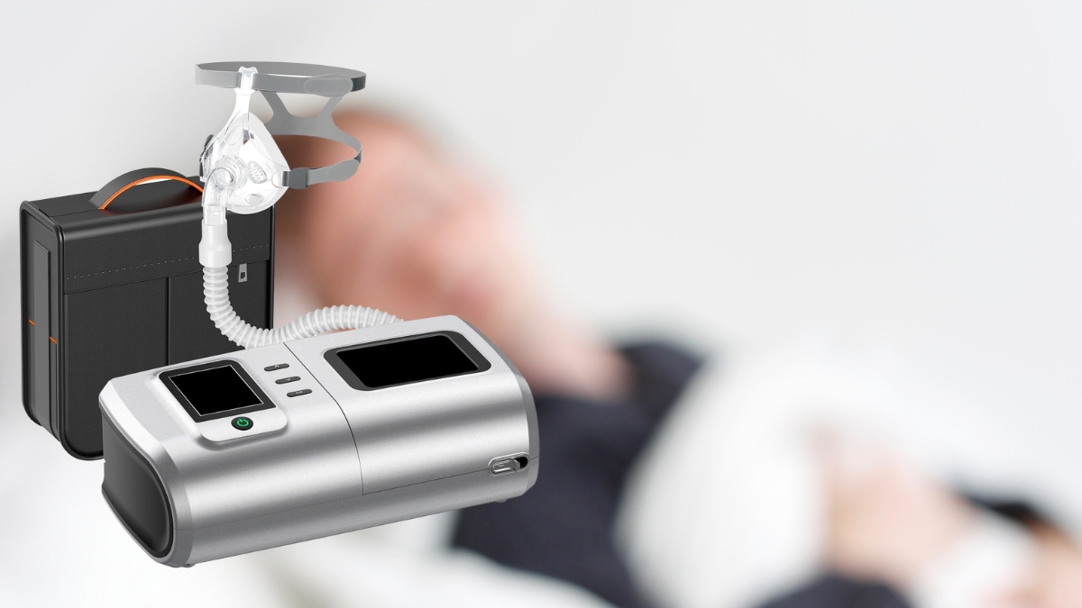 A CPAP machine with a mask and carrying case is shown in front of a blurred image of a person sleeping.