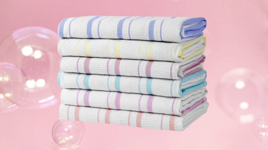 A neatly stacked pile of white kitchen towels with colorful striped edges is set against a pink background with floating bubbles.