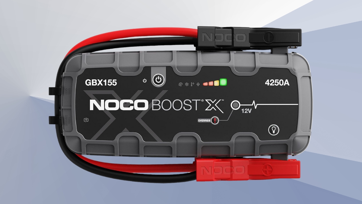 NOCO Boost X GBX155 portable lithium jump starter shown with attached jumper cables and LED indicators.