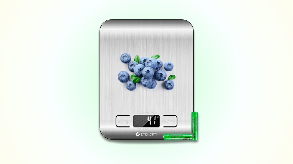 A digital kitchen scale from top Amazon deals displays blueberries weighing 41 grams, with two green batteries beside it.