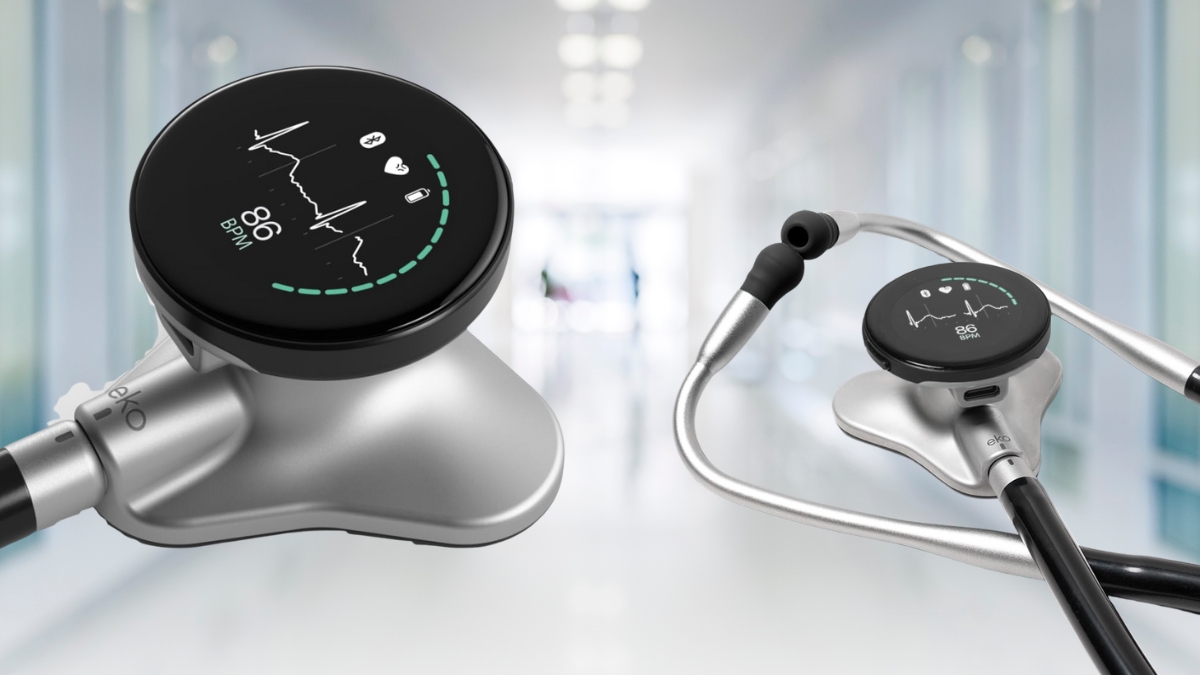 Close-up of the Eko CORE 500 digital stethoscope showing ECG display and heart rate on a modern touchscreen in a clinical hallway.