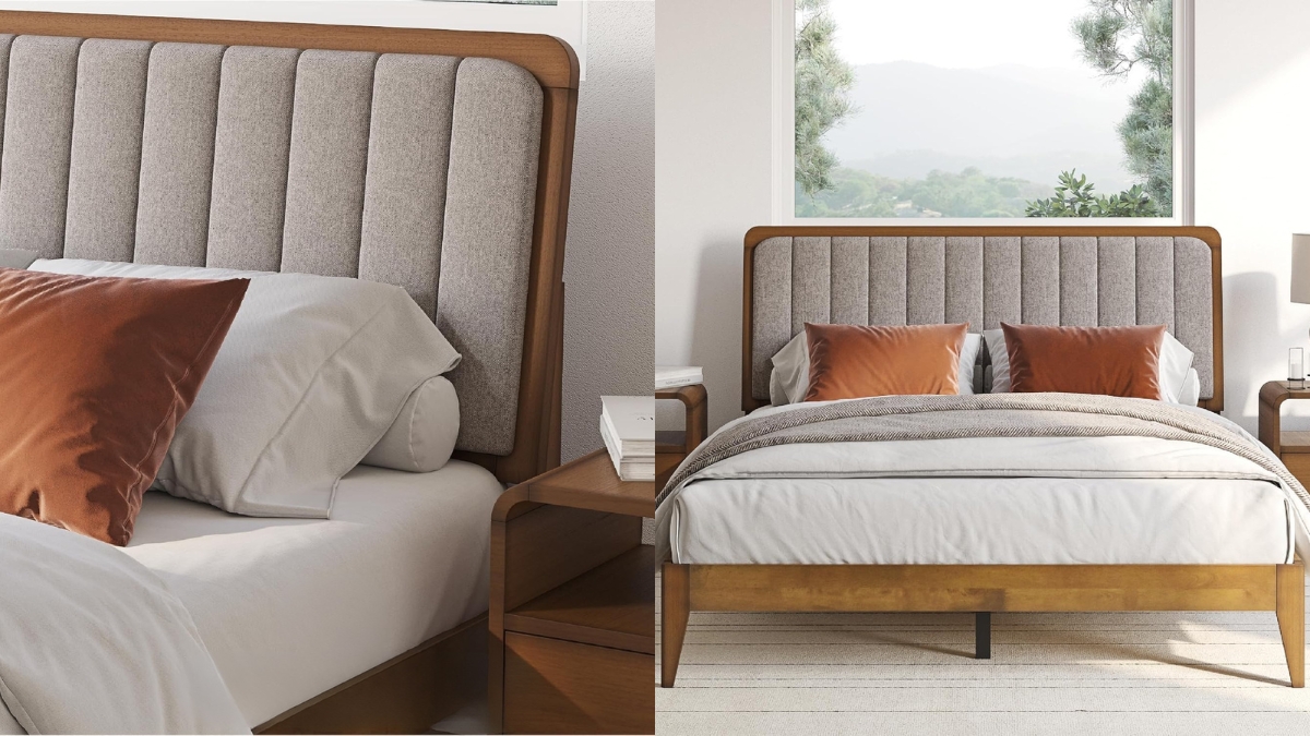 A wooden mid century modern bed frame with a padded gray fabric headboard, shown fully made with pillows and natural light.