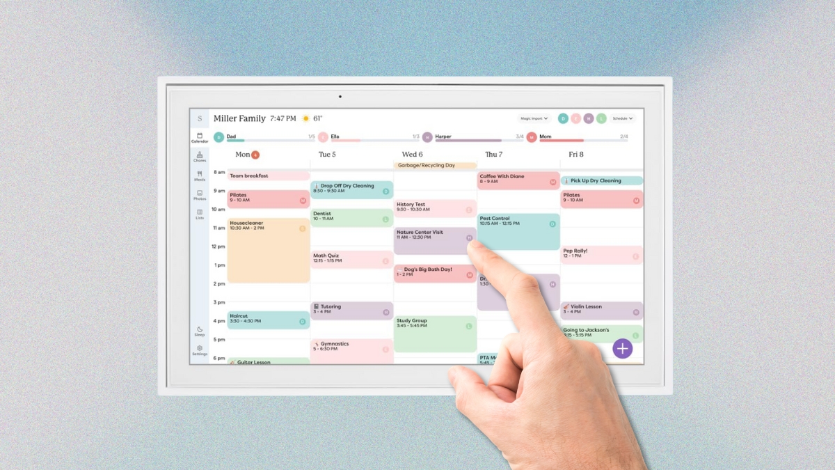 A hand taps a Skylight digital calendar showing a color-coded weekly family schedule on a touchscreen display.