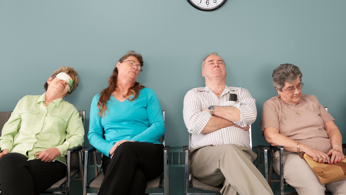 Four older adults asleep on waiting room chairs under a clock, showing long wait times.