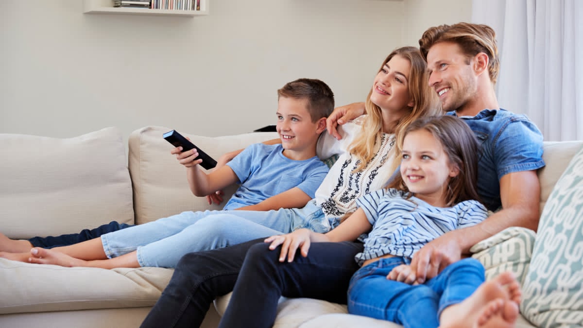"Family enjoying the best family shows on Disney Plus while watching animated entertainment together in a cozy living room."